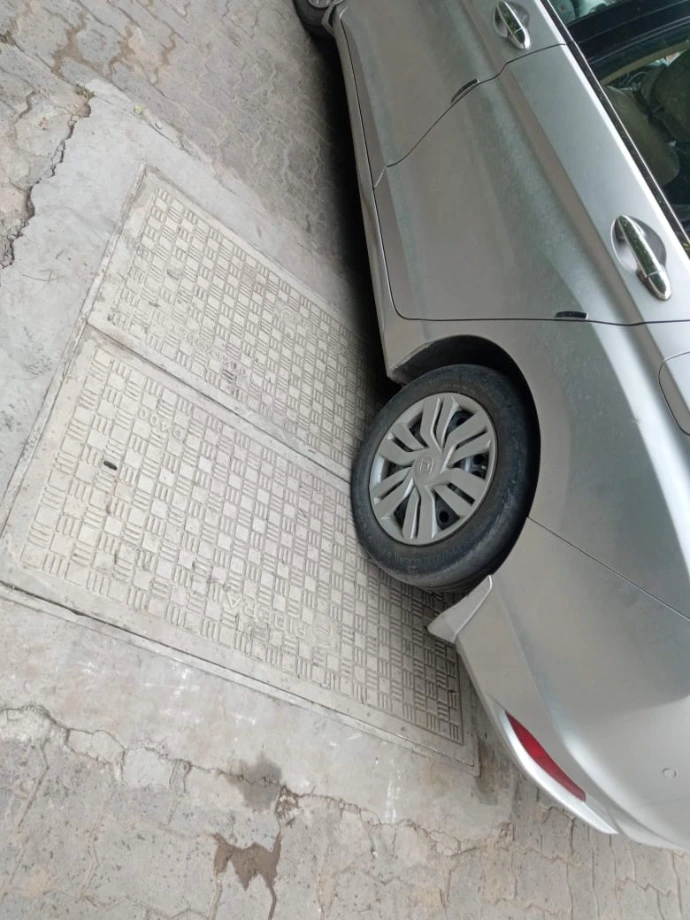 Recessed rectangular manhole cover blended into paved area