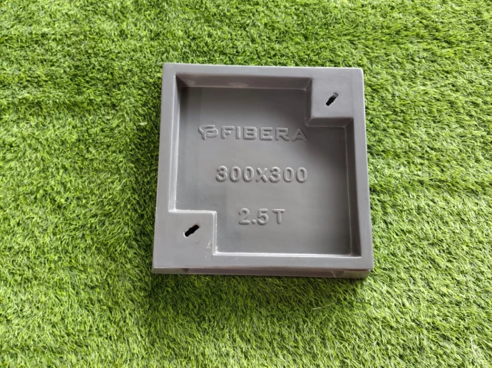 Recessed manhole cover tray installed flush in green lawn and landscape grass
