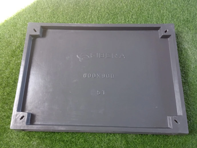 Square composite recessed manhole cover installed flush in paving