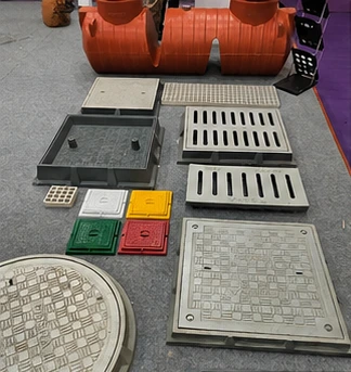 Assortment of different FRP manhole covers and drainage gratings on display.