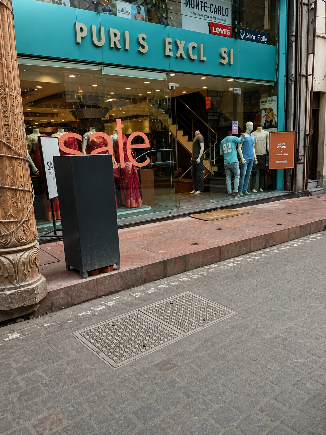 Black rectangular FRP cover installed on a pedestrian brick walkway.