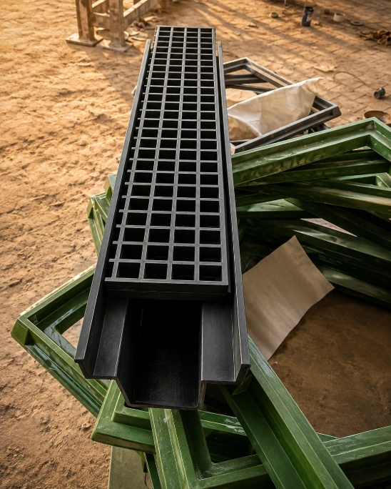 Hand installing a square green FRP drainage grating.